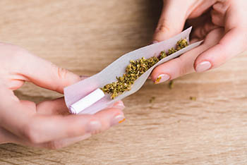 woman's hands rolling a joint