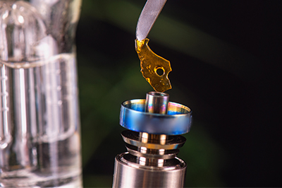 a piece of shatter being placed in a dab rig