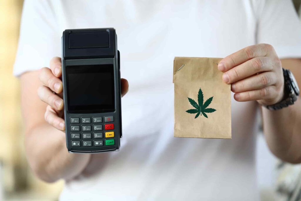 a person holding a credit card and a bag | cannabis delivery