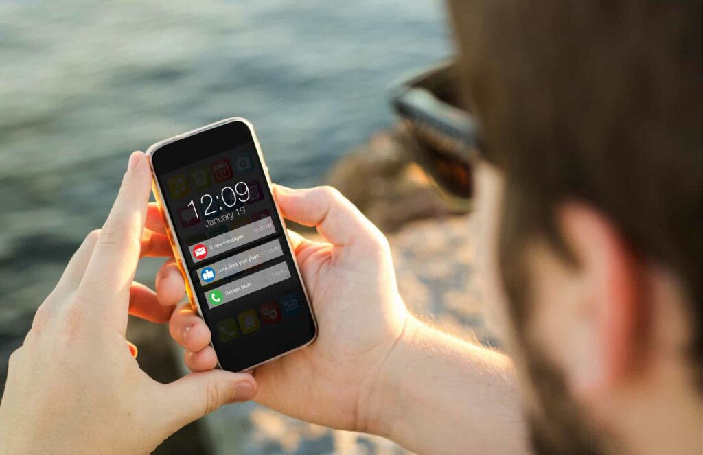 man holding his phone receiving updates on his cannabis delivery